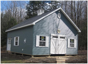 This pretty, customized Ashville Barn was still under construction at the time of the photo. It still needs gravel fill for the floor and outside edges. The plan set is available at BarnsBarnsBarns.com 